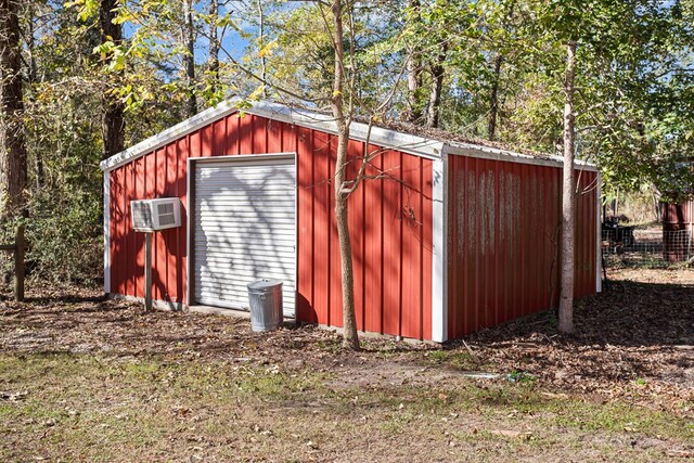 view of outbuilding with an AC wall unit and a garage