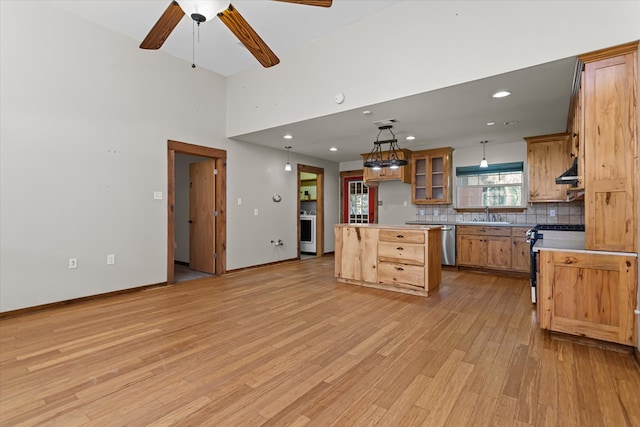 kitchen featuring stainless steel appliances, ceiling fan, a center island, light hardwood / wood-style floors, and hanging light fixtures