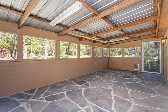 unfurnished sunroom featuring vaulted ceiling