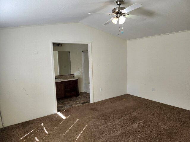 carpeted spare room with ceiling fan and vaulted ceiling