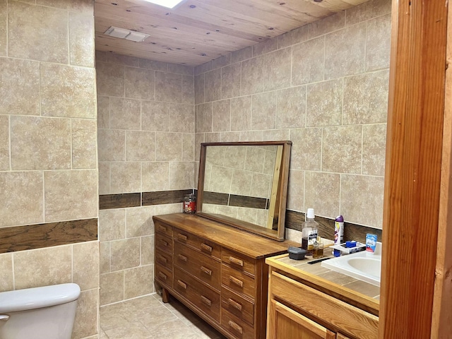 bathroom featuring tile patterned floors, toilet, tile walls, and wood ceiling