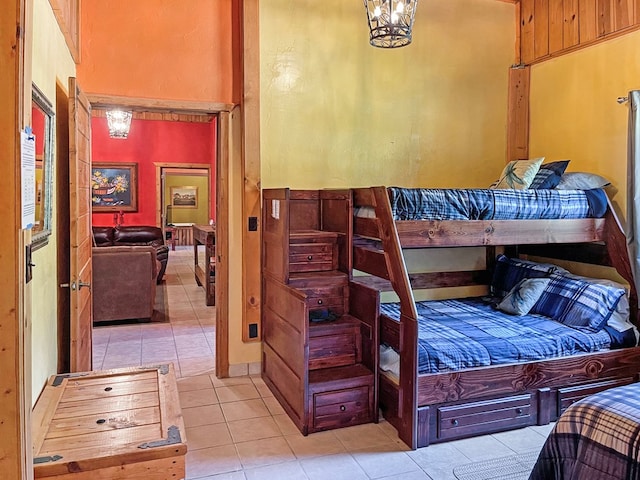 bedroom featuring a towering ceiling and light tile patterned floors