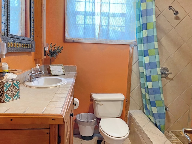 full bathroom with a tile shower, toilet, and vanity
