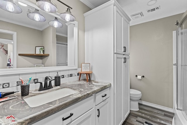 538 Timpson St, Timpson, TX 75975 - bathroom featuring wood finished floors, visible vents, ornamental molding, and toilet
