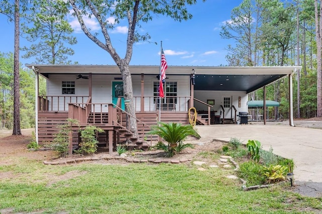 back of property featuring ceiling fan, a yard, a porch, and a carport