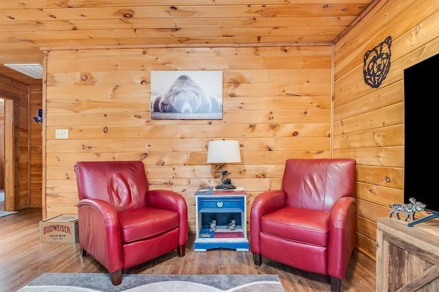 living area featuring hardwood / wood-style flooring, wooden ceiling, and wooden walls