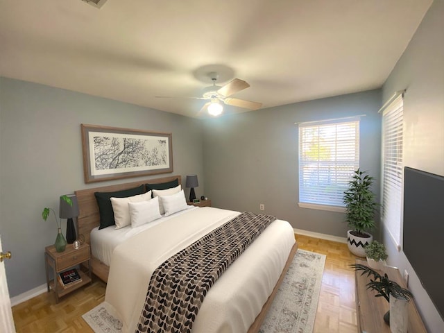 bedroom with ceiling fan and light parquet floors