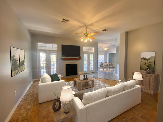 living room with ceiling fan, french doors, and light parquet flooring