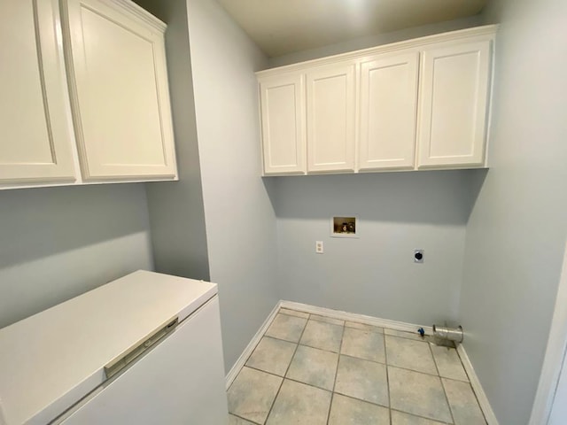 washroom featuring electric dryer hookup, cabinets, light tile patterned floors, and washer hookup