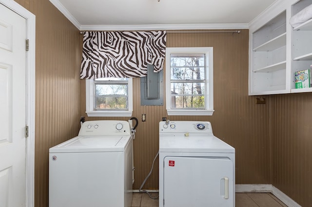 laundry room with light tile patterned floors, washing machine and dryer, ornamental molding, and a wealth of natural light