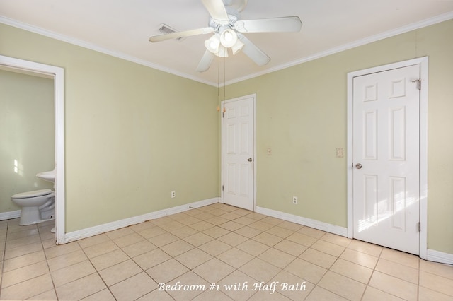 unfurnished bedroom featuring ceiling fan, ensuite bathroom, light tile patterned floors, and crown molding