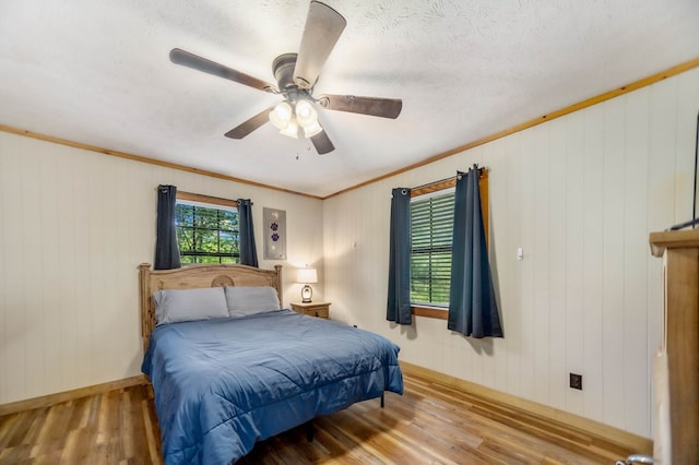 914 County Road 849, Cushing, TX 75760 - bedroom with wooden walls, light wood-style floors, and ceiling fan