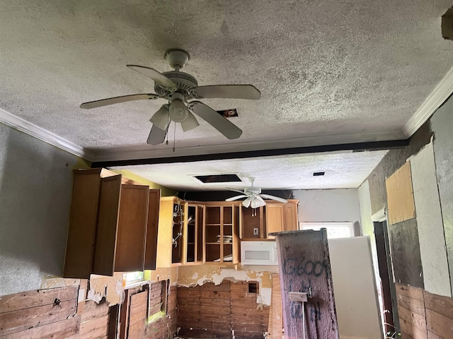 kitchen with beamed ceiling, a textured ceiling, and crown molding