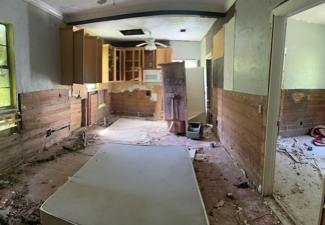 kitchen with ceiling fan, plenty of natural light, beamed ceiling, and crown molding