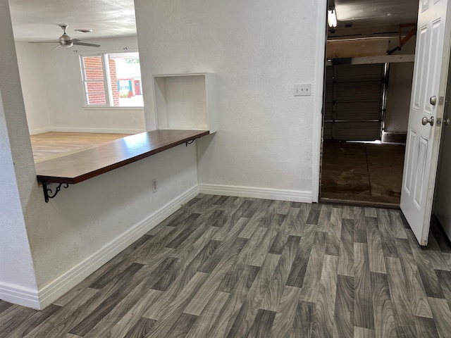 unfurnished dining area with ceiling fan and dark wood-type flooring