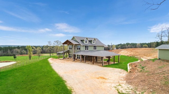 farmhouse-style home with a rural view, an outdoor structure, and a front yard