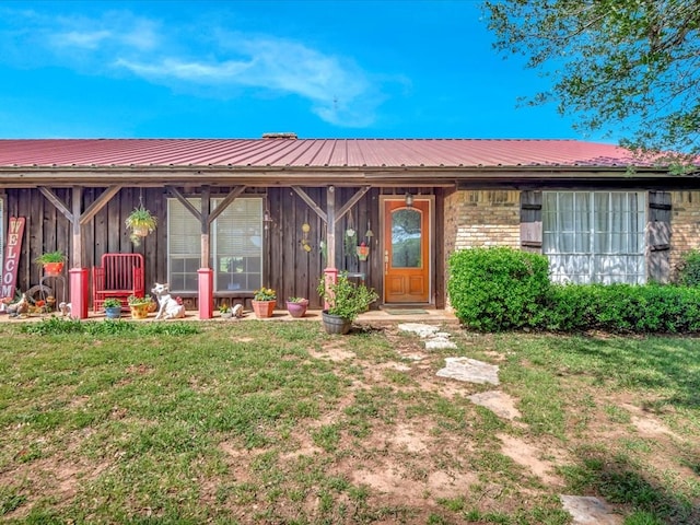 1145 State Highway 21e, San Augustine, TX 75972 - doorway to property featuring board and batten siding, a lawn, and metal roof