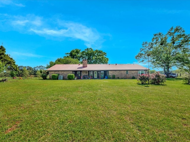 1145 State Highway 21e, San Augustine, TX 75972 - rear view of property featuring a lawn, a chimney, and metal roof