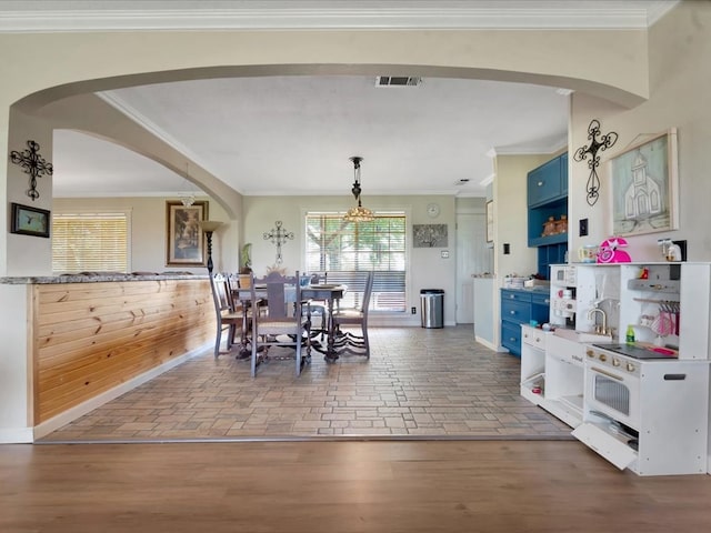 1145 State Highway 21e, San Augustine, TX 75972 - dining room featuring brick floor, arched walkways, baseboards, ornamental molding, and visible vents