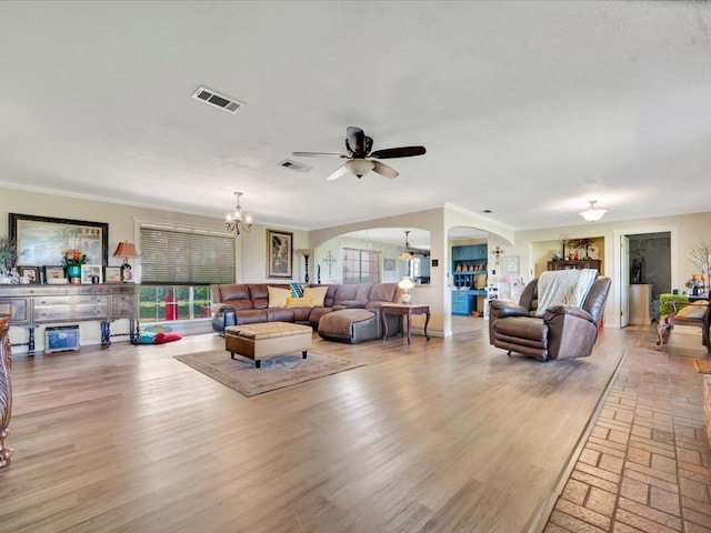 1145 State Highway 21e, San Augustine, TX 75972 - living area with arched walkways, visible vents, ornamental molding, and ceiling fan with notable chandelier