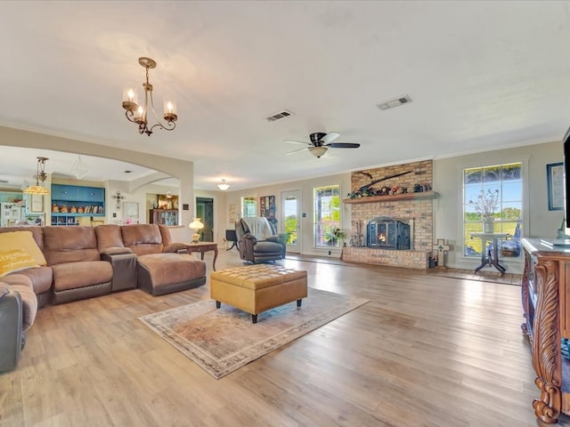 1145 State Highway 21e, San Augustine, TX 75972 - living area with arched walkways, a brick fireplace, wood finished floors, and visible vents