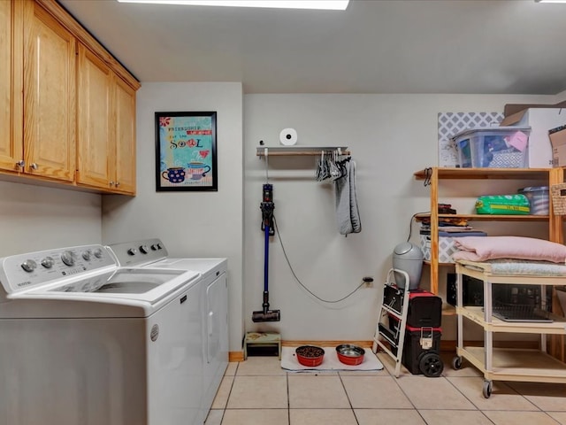 laundry area featuring cabinets, washer and clothes dryer, and light tile patterned floors