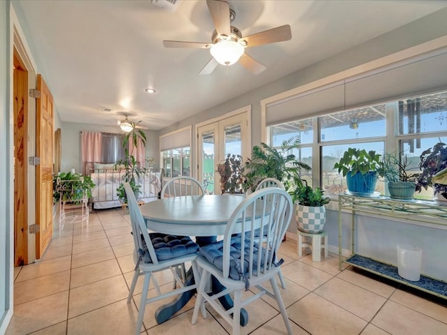 tiled dining room with plenty of natural light and ceiling fan