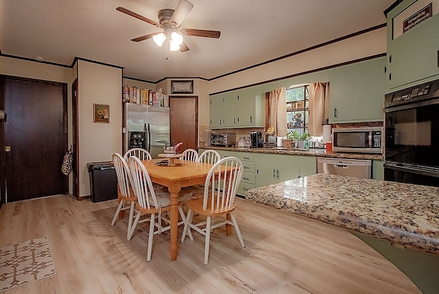 dining space featuring ceiling fan, sink, light wood-type flooring, and crown molding