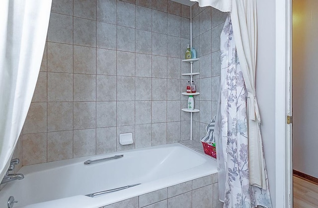 bathroom with shower / tub combo and wood-type flooring