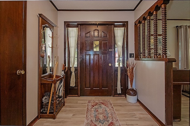 foyer entrance with crown molding and light hardwood / wood-style flooring