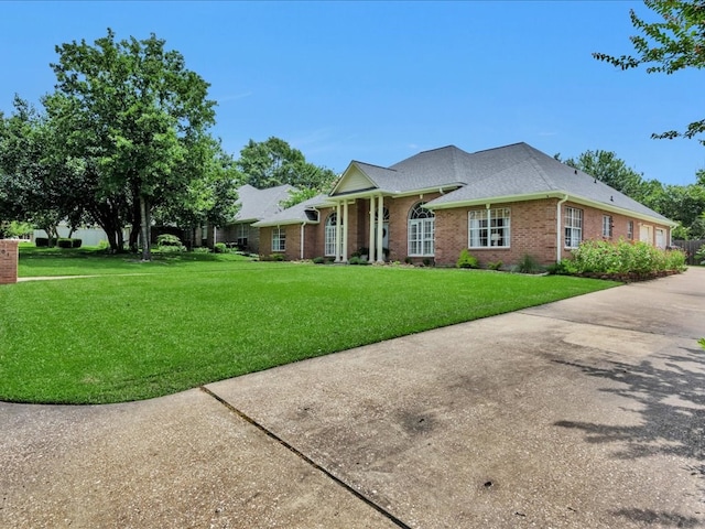 301 Sawgrass Cir, Lufkin, TX 75901 - view of front of house featuring brick siding, a front yard, and a shingled roof