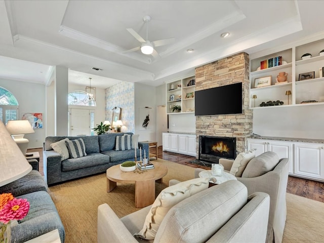 301 Sawgrass Cir, Lufkin, TX 75901 - living room with a raised ceiling, ceiling fan, a stone fireplace, ornamental molding, and wood finished floors