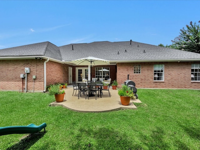 301 Sawgrass Cir, Lufkin, TX 75901 - rear view of house with brick siding, a patio area, a lawn, and a shingled roof