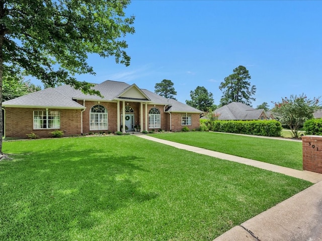 301 Sawgrass Cir, Lufkin, TX 75901 - view of front facade featuring a front yard, roof with shingles, and brick siding