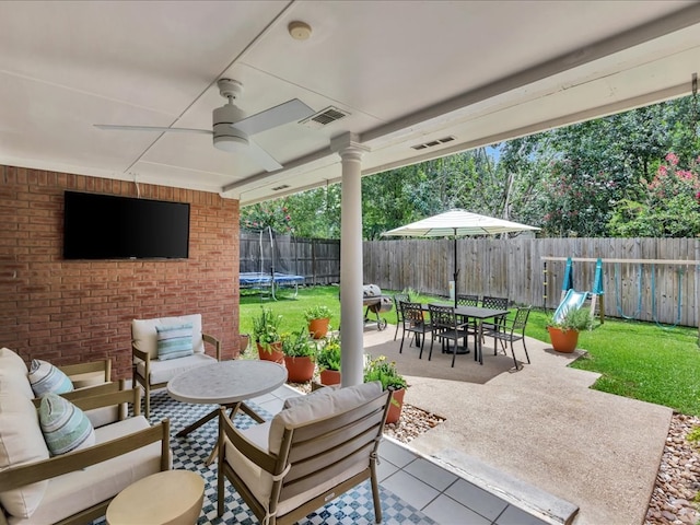 301 Sawgrass Cir, Lufkin, TX 75901 - fenced backyard with a trampoline, an outdoor hangout area, a patio area, outdoor dining area, and ceiling fan