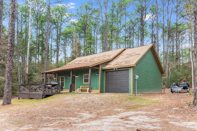 view of front facade featuring a garage, dirt driveway, a porch, and board and batten siding