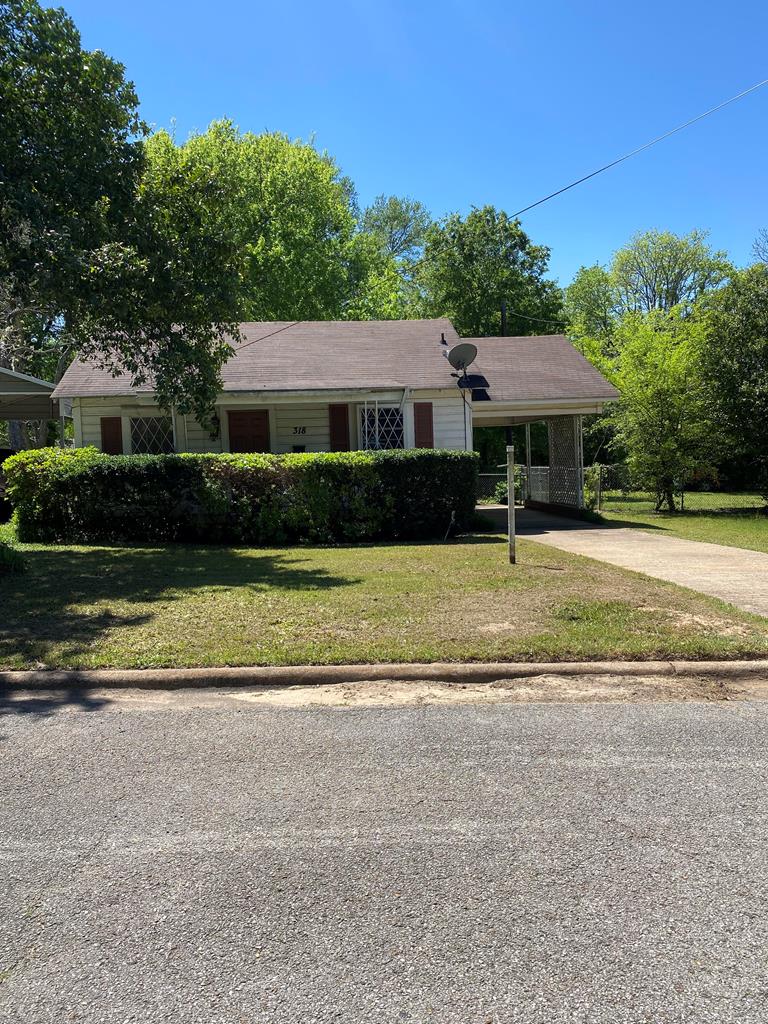 ranch-style house with a front lawn and a carport