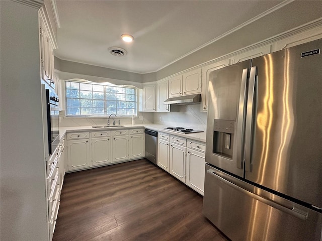 kitchen featuring appliances with stainless steel finishes, dark hardwood / wood-style floors, sink, white cabinets, and backsplash