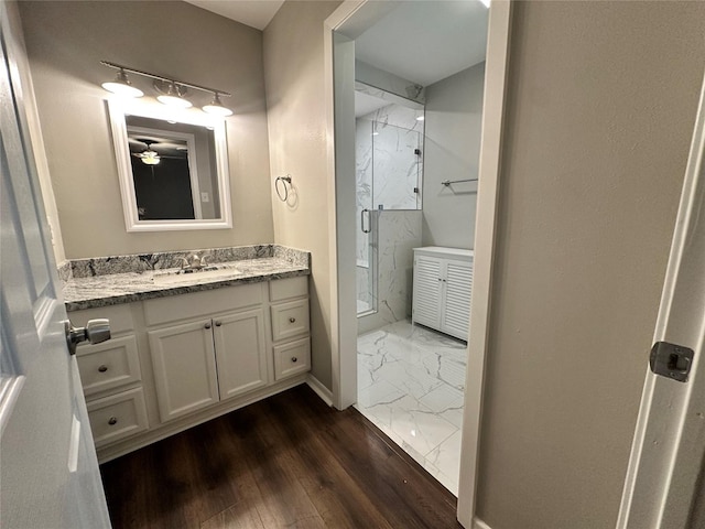 bathroom featuring vanity, wood-type flooring, and a shower with shower door