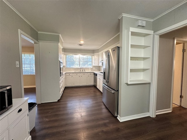 kitchen featuring appliances with stainless steel finishes, built in features, sink, white cabinets, and crown molding