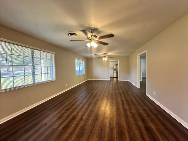 spare room featuring dark wood-type flooring and ceiling fan