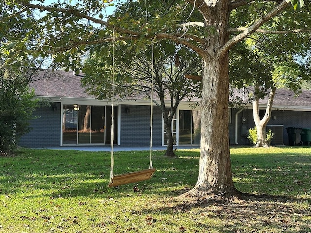 back of property with a yard and a patio area