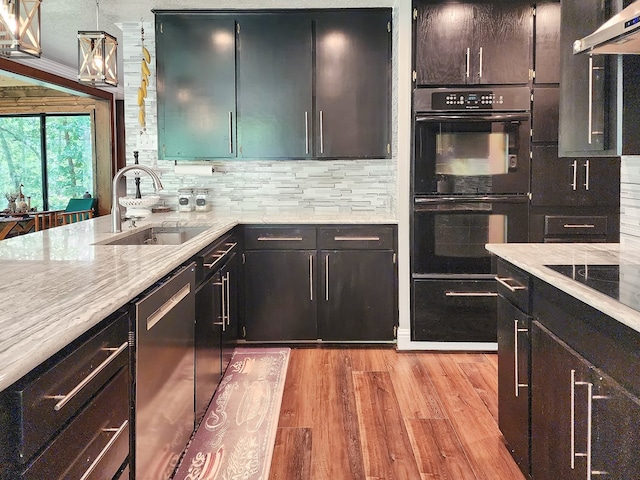 203 Bogey Ln, Brookeland, TX 75931 - kitchen with black appliances, ventilation hood, light wood-type flooring, backsplash, and light stone countertops