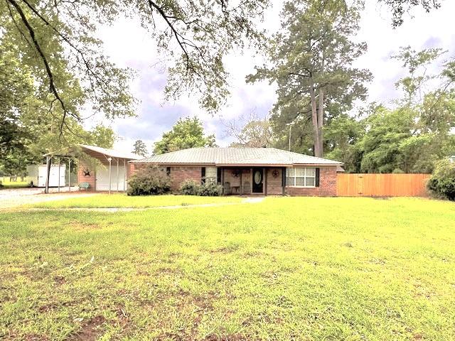 back of house featuring a yard and a carport