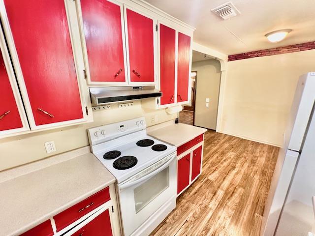 kitchen featuring light hardwood / wood-style floors, white appliances, and range hood