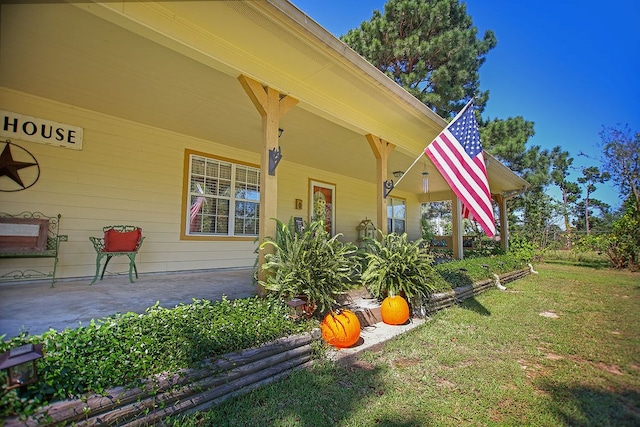 entrance to property featuring covered porch and a lawn