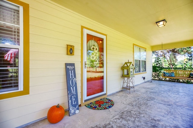 view of exterior entry featuring covered porch