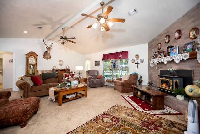 living room featuring lofted ceiling with beams, carpet floors, a wood stove, and ceiling fan