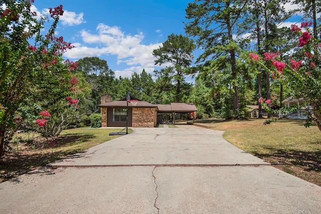 view of front of property featuring a front lawn and a carport