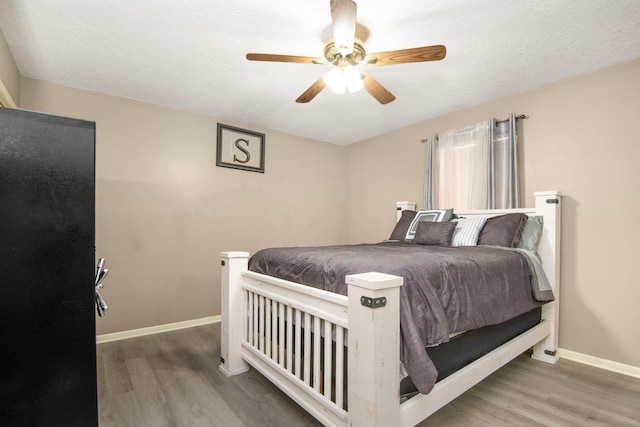 bedroom featuring ceiling fan, a textured ceiling, and hardwood / wood-style flooring